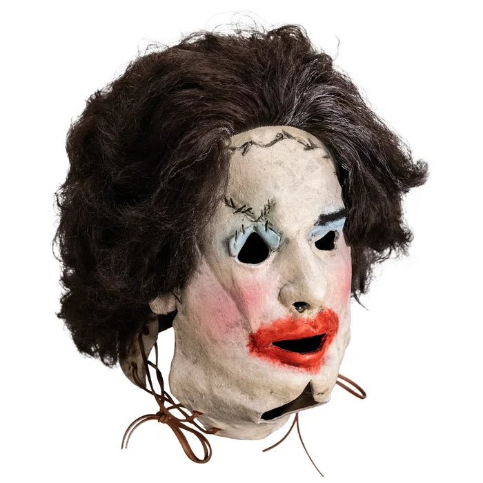 Mask with brown hair, white face, black eyes, red lips, and brown strings on a white background