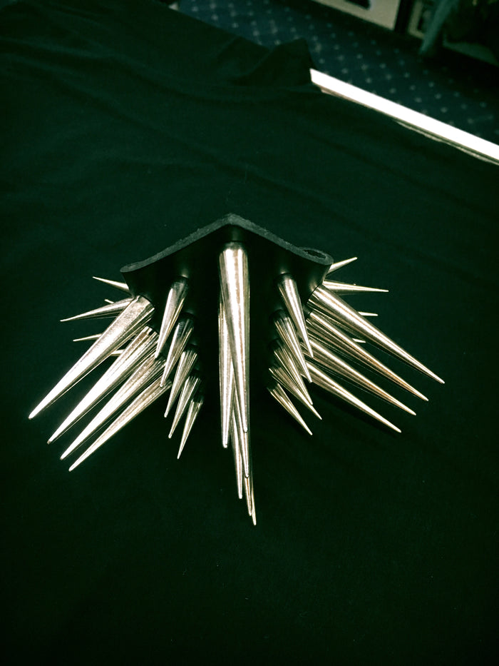 triangular shaped black leather gauntlet bracelet with multiple rows of two inch silver needle spikes