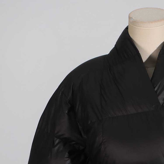 Close-up of a women's black winter coat with belt showcasing its sleek design and elegant collar