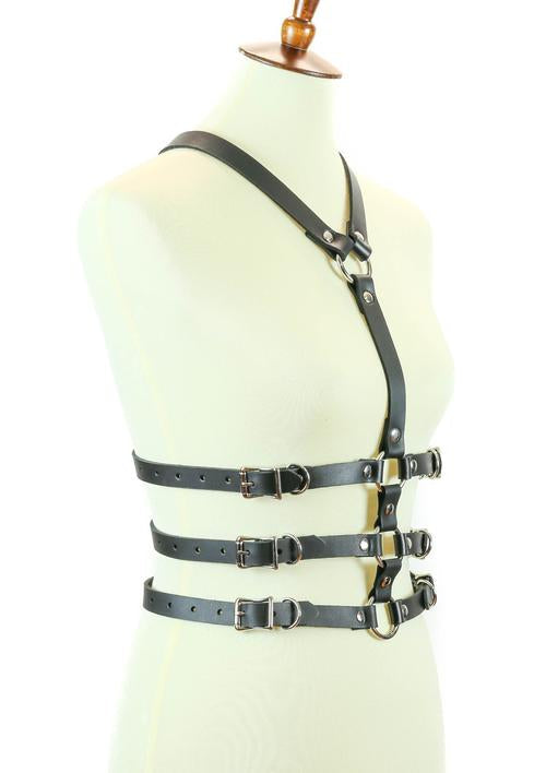 mannequin displaying side of black leather y shaped body harness. shows three adjustable buckles on each side of torso and silver o ring details